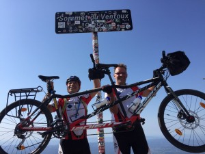 Rachid et Régis portent haut dans le ciel leur tandem au pied du panneau qui indique "Sommet du Ventoux 1909 mètres"