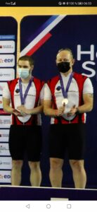 Denis et Raphaël avec leurs médailles sur le podium, qui applaudissent